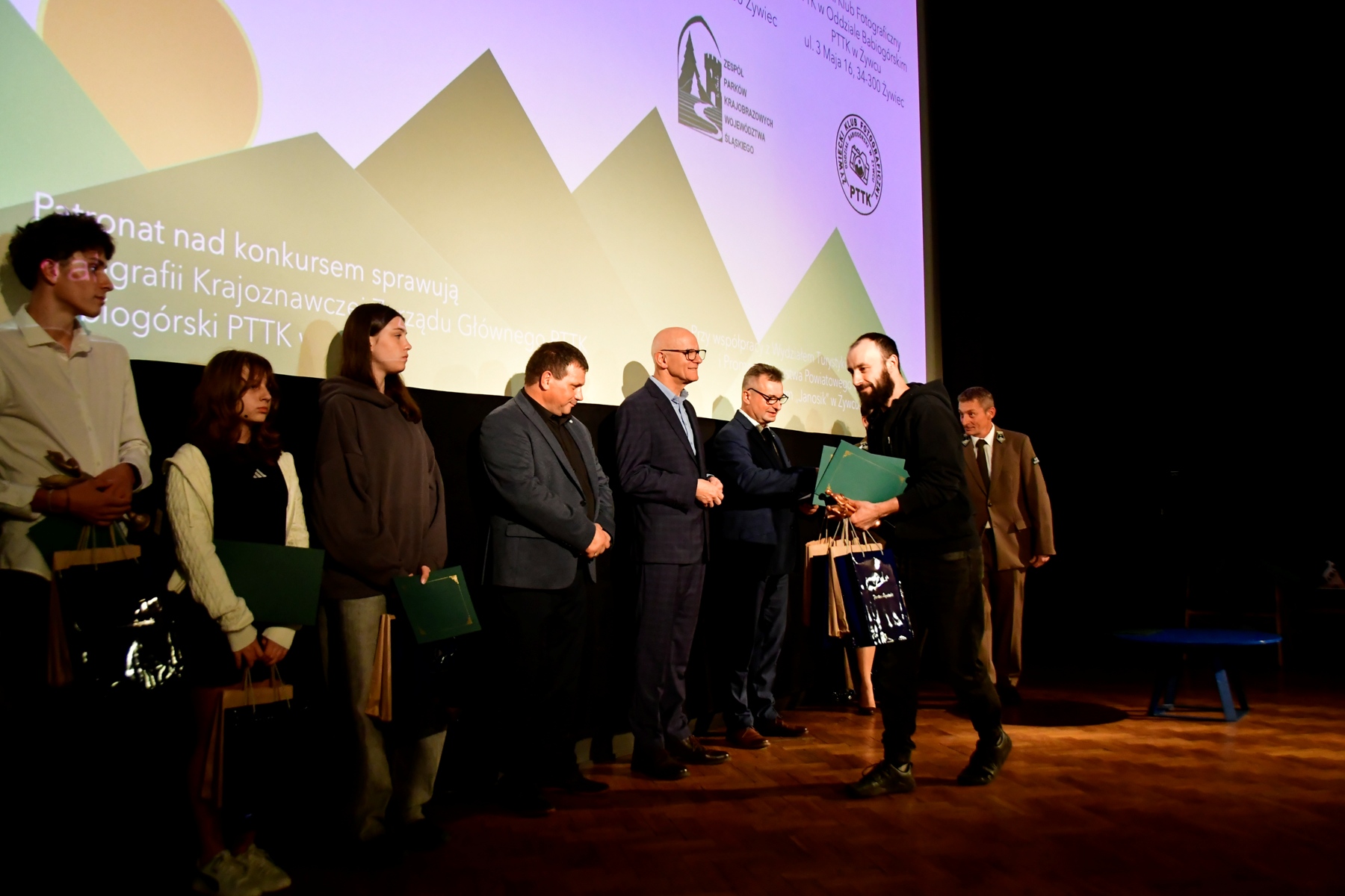 Laureat konkursu odbiera nagrodę. W otoczeniu pozostali organizatorzy konkursu.