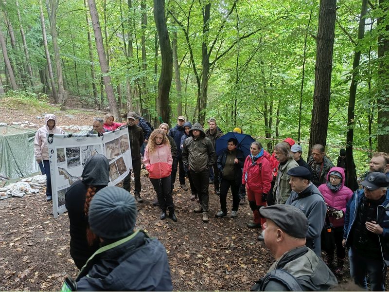 Drugi dzień konferencji, wykład terenowy w Dolinie Udorki – Pani dr Magdalena Sudoł-Procyk na zawieszonych pomiędzy drzewami planszach przedstawia etapy prowadzenia badań naukowych. 