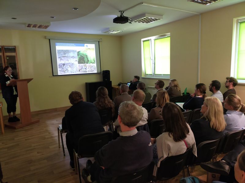 Na pierwszym planie zdjęcia referat wygłasza dr Magdalena Sudoł-Procyk, na drugim planie osoby uczestniczące w konferencji. 