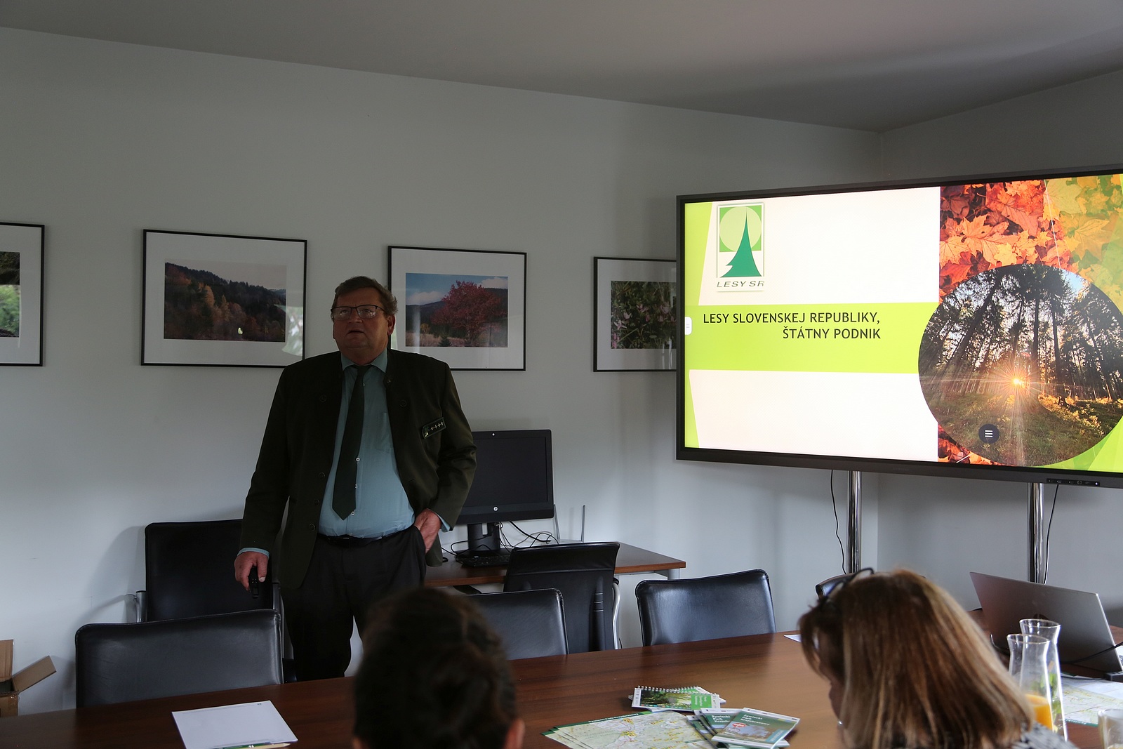 Sala konferencyjna. Przy stołach siedzą uczestnicy szkolenia, po środku prelegentka wygłasza prelekcje wyświetlając na ekranie prezentację multimedialną.